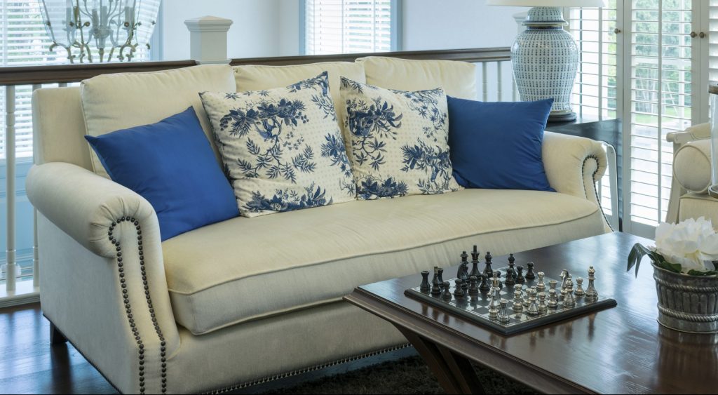 Living room with blue and white couch and pillows with a chess board